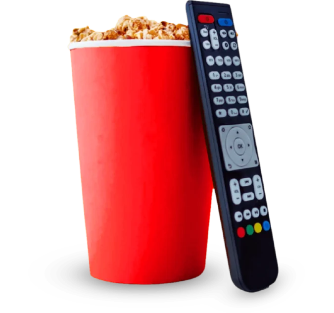 A red cup of popcorn next to a remote control on a gray background.