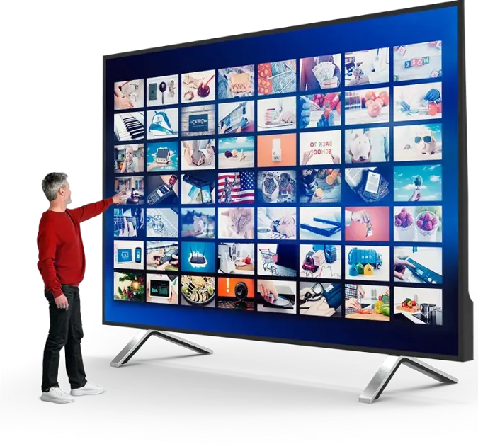 A man pointing at a TV screen displaying numerous cable tv channels.