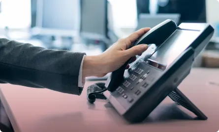 A hand holding a telephone