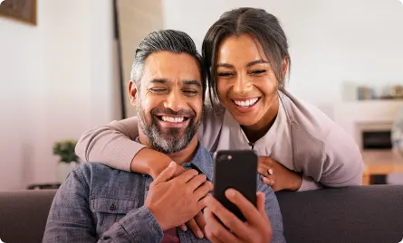 A guy and a woman smiling while looking at a phone