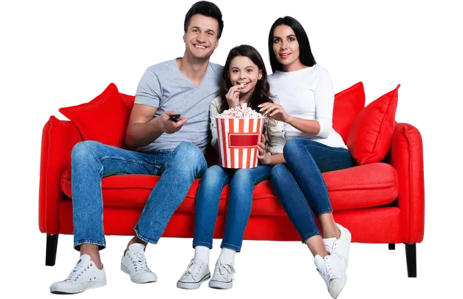 A family enjoying a movie night on a red couch, with popcorn in hand, creating a cozy and relaxing atmosphere.